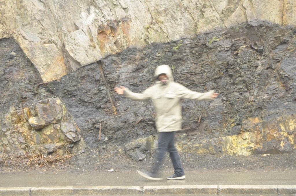 - Hey, man, need some scale?  - Sure, mate, I am a geologist!  A slightly wider image of the fault, with the two sills. The image may give the impression that the black shale is wedged in between the light syenite, but it really is the other way around: The shale is much older, and happens to be preserved in between two individual sills.  