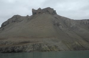 Like a medieval castle on top of the hill: A hard limestone cap on top of the sand and salt, with Gothic windows created by karst solution of carbonate. 