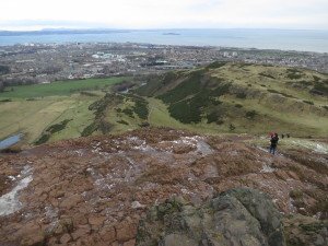 Top of Arthur's Seat, with the hard volcanic rocks in the foreground, and view towards Firth of Forth and Edinburgh's harbour. 